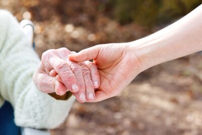 Senior Lady Holding Hands with Young Caretaker © Melpomene - Fotolia